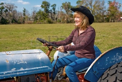 3011778-hermosa-mujer-madura-de-conducir-un-tractor-en-la-granja.jpg