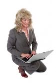 70-atractiva-mujer-de-negocios-ejecutiva-de-rodillas-mientras-trabajaba-en-un-ordenador-portatil.jpg