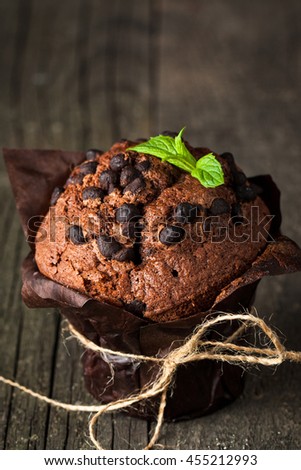colate-dark-muffin-with-a-leaf-of-mint-on-a-wooden-table-with-cinnamon-anise-chocolate-455212993.jpg