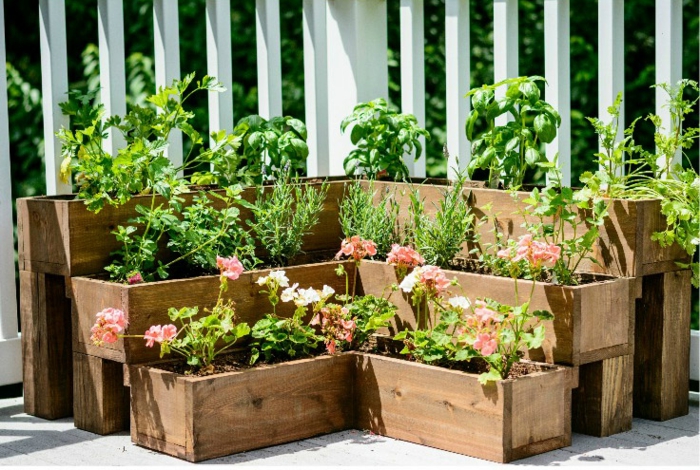 jardineras-de-madera-macetero-grande-forma-L-madera-geranios-rosados-basilico-hierbas.jpg