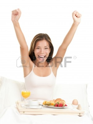 r-de-desayuno-de-manana-feliz-sonriendo-comer-desayuno-en-la-cama-estiramiento-mirando-la-camara.jpg