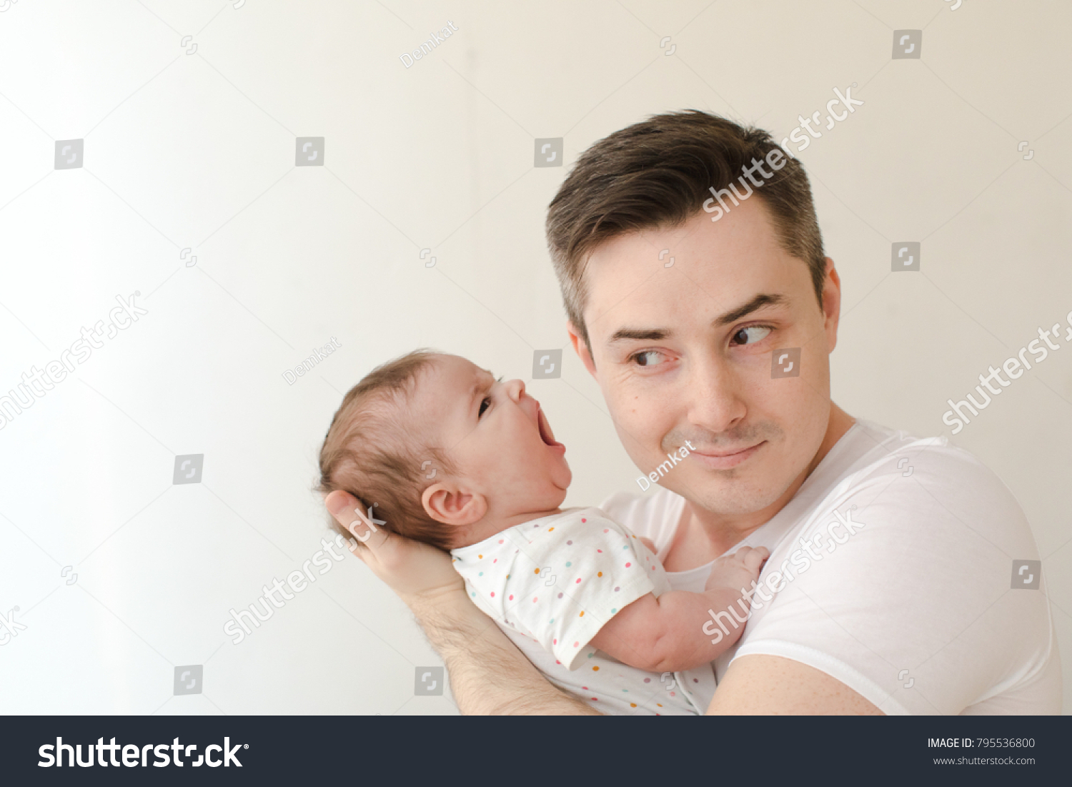 stock-photo-cheerful-adult-man-listening-to-infant-son-shouting-to-his-ear-795536800.jpg