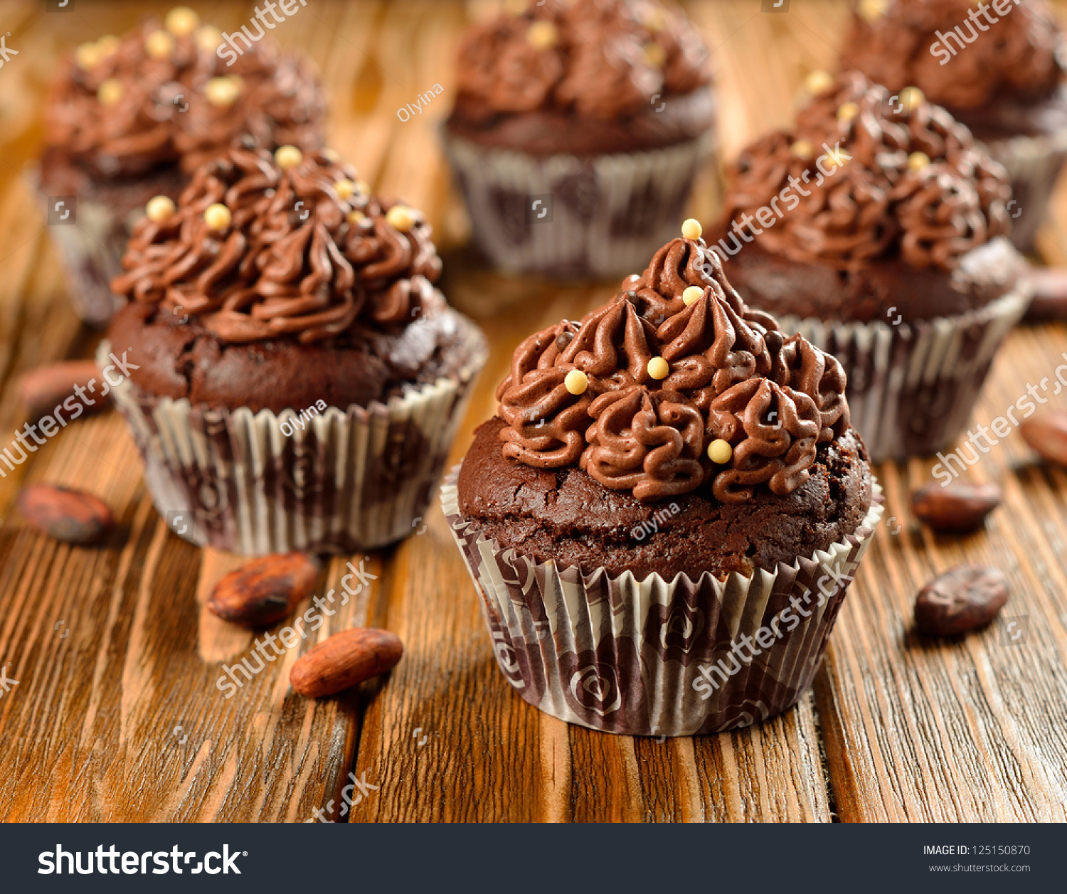stock-photo-chocolate-cupcakes-on-a-brown-table-125150870.jpg
