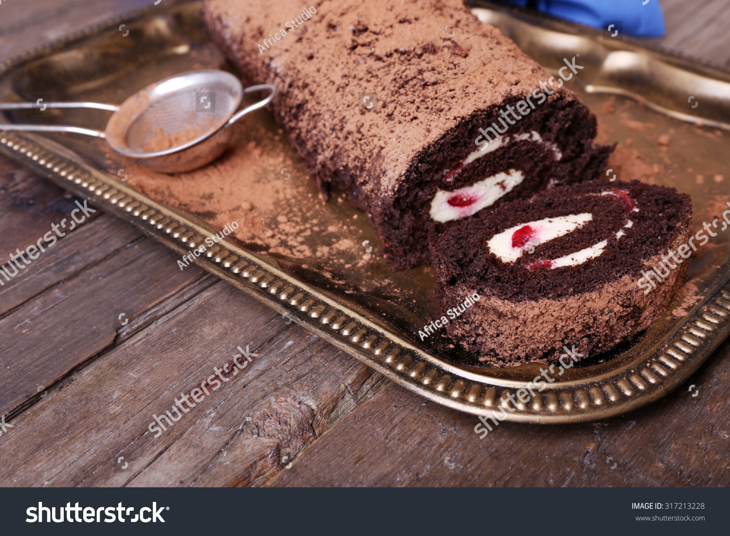 stock-photo-chocolate-roll-with-cream-and-berries-on-table-close-up-317213228.jpg