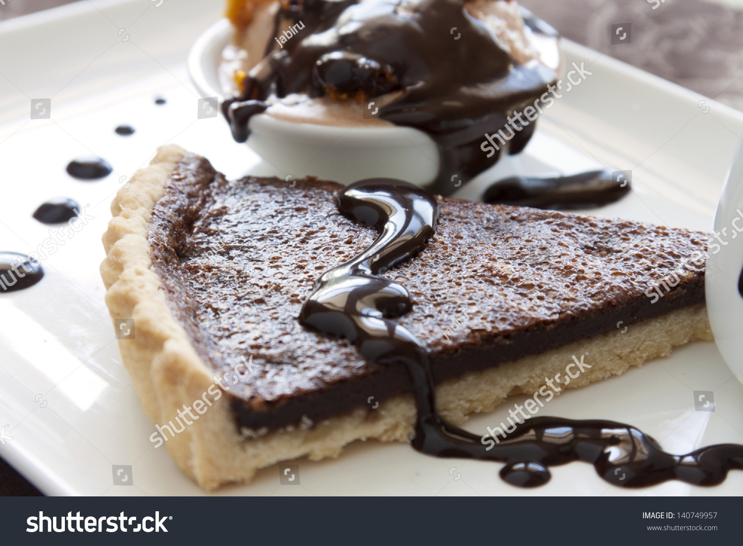 stock-photo-chocolate-tart-slice-and-ice-cream-with-melted-dripping-chocolate-sauce-140749957.jpg