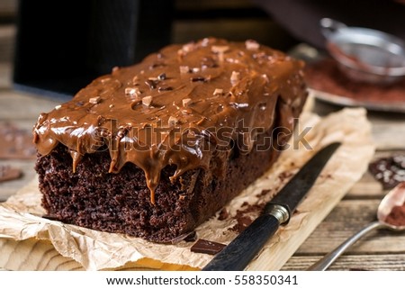stock-photo-moist-chocolate-cake-with-milk-chocolate-topping-glaze-and-cocoa-powder-558350341.jpg