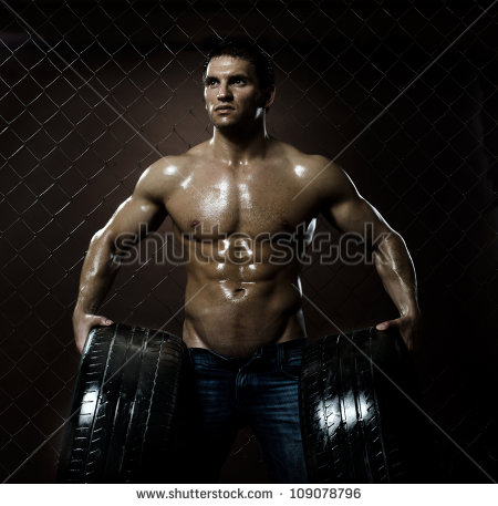 the-very-muscular-handsome-sexy-guy-with-rubber-tire-on-netting-steel-fence-background-109078796.jpg