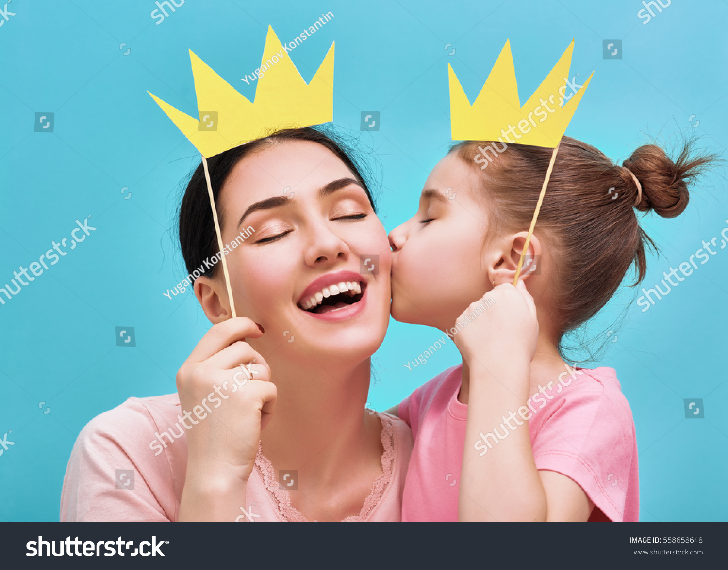 y-family-on-a-background-of-bright-blue-wall-mother-and-her-daughter-girl-with-a-paper-558658648.jpg